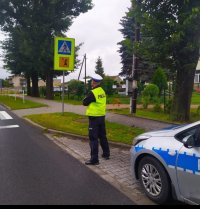 Policjant ruchu drogowego czuwający nad bezpieczeństwem uczestników ruchu drogowego w rejonie przejścia dla pieszych