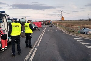 miejsce wypadku drogowego, policjanci prowadzą oględziny, widoczne wraki rozbitych samochodów