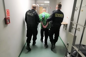policjanci prowadzą zatrzymanego mężczyznę