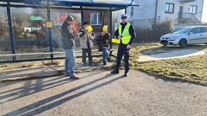 Policjant przekazuje kamizelkę odblaskową