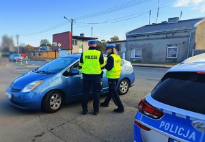 Policjanci dokonujący kontroli pojazdu.