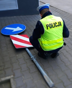 Policjant i znak drogowy.