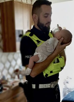 Policjant karmi niemowlę.